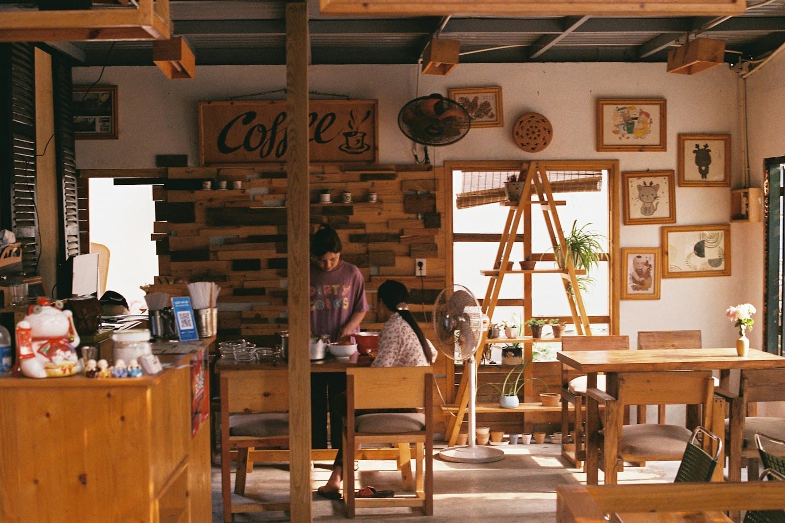 Staff at work behind the counter of a small wooden café.